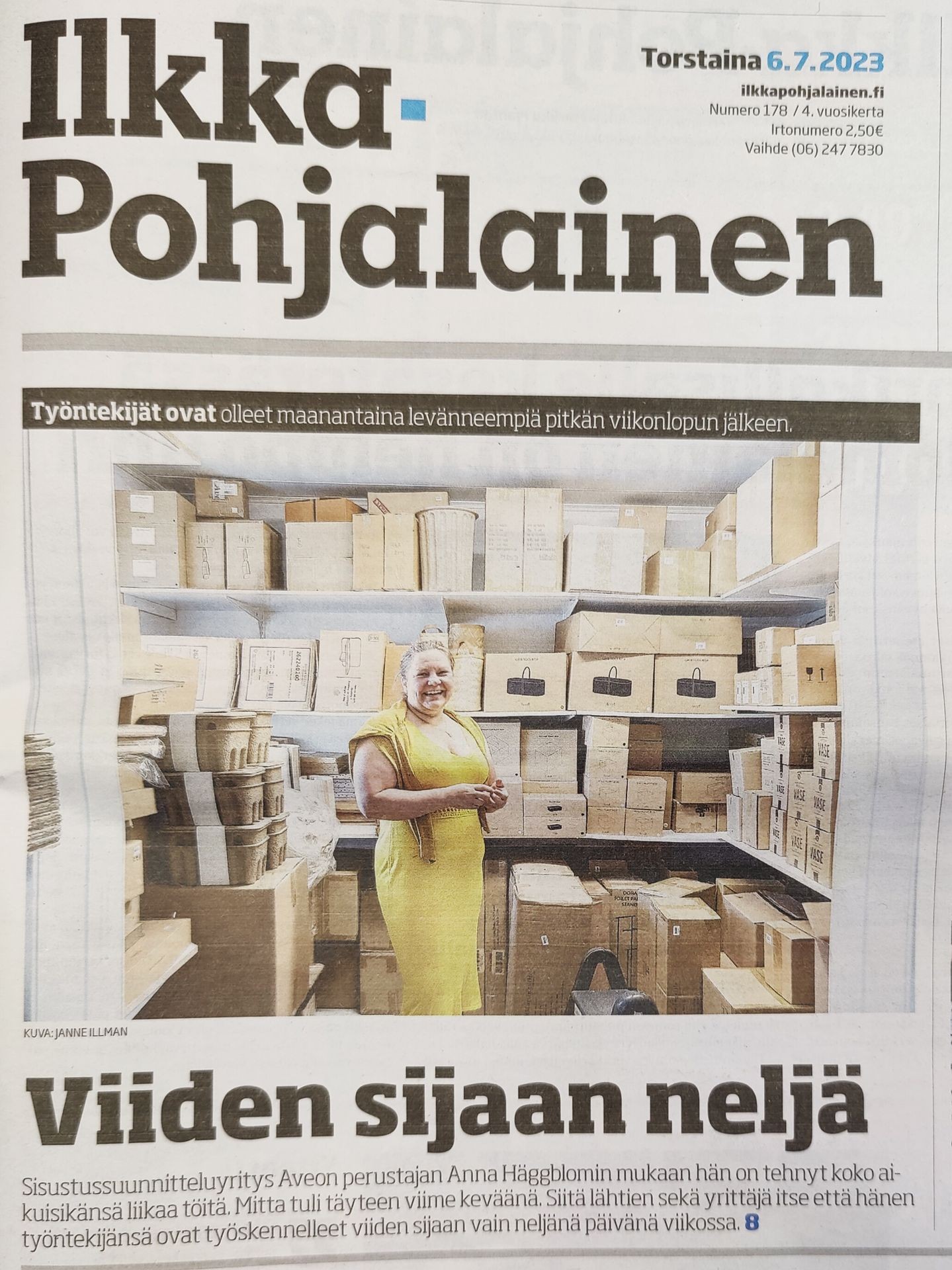 Person in a yellow dress stands in a storage room filled with shelves of various sized cardboard boxes.