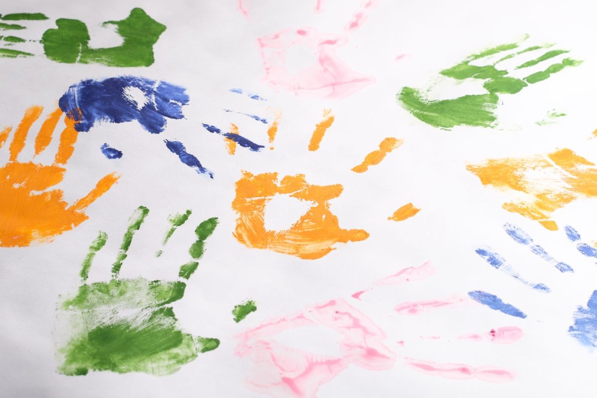 set of handprints of children left with colorful paints on a white background